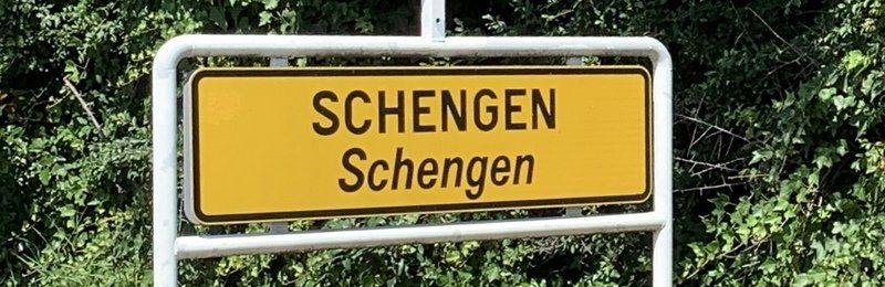 Ein gelbes Schild mit der Aufschrift Schengen Schengen