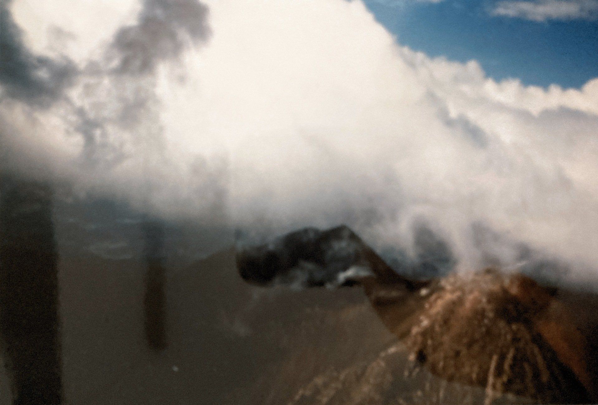 Ein verschwommenes Bild eines von Wolken bedeckten Berges.