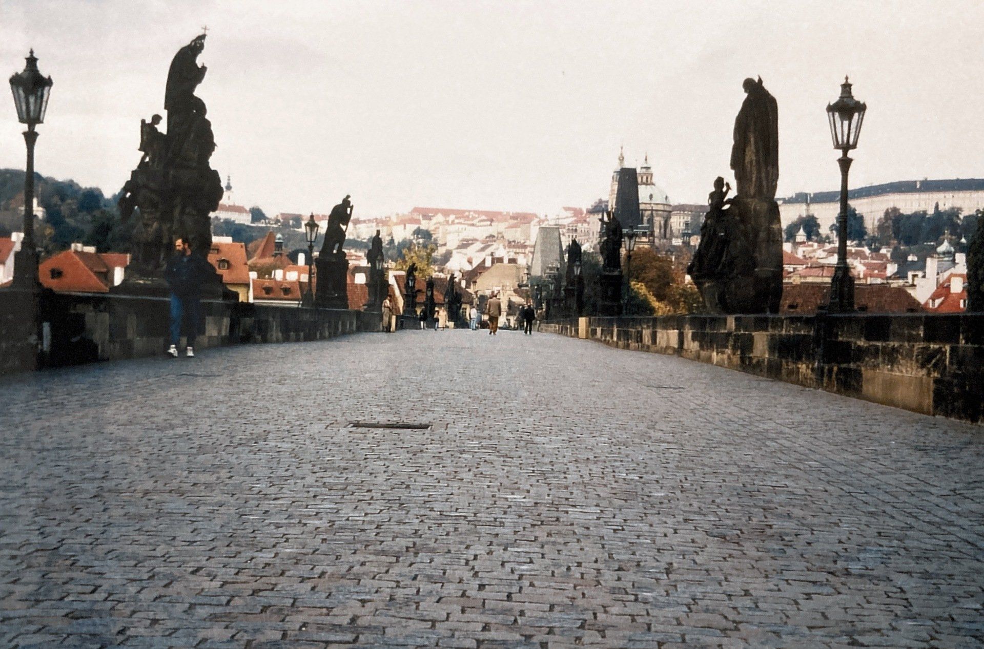 Eine Kopfsteinpflasterbrücke mit Statuen an der Seite