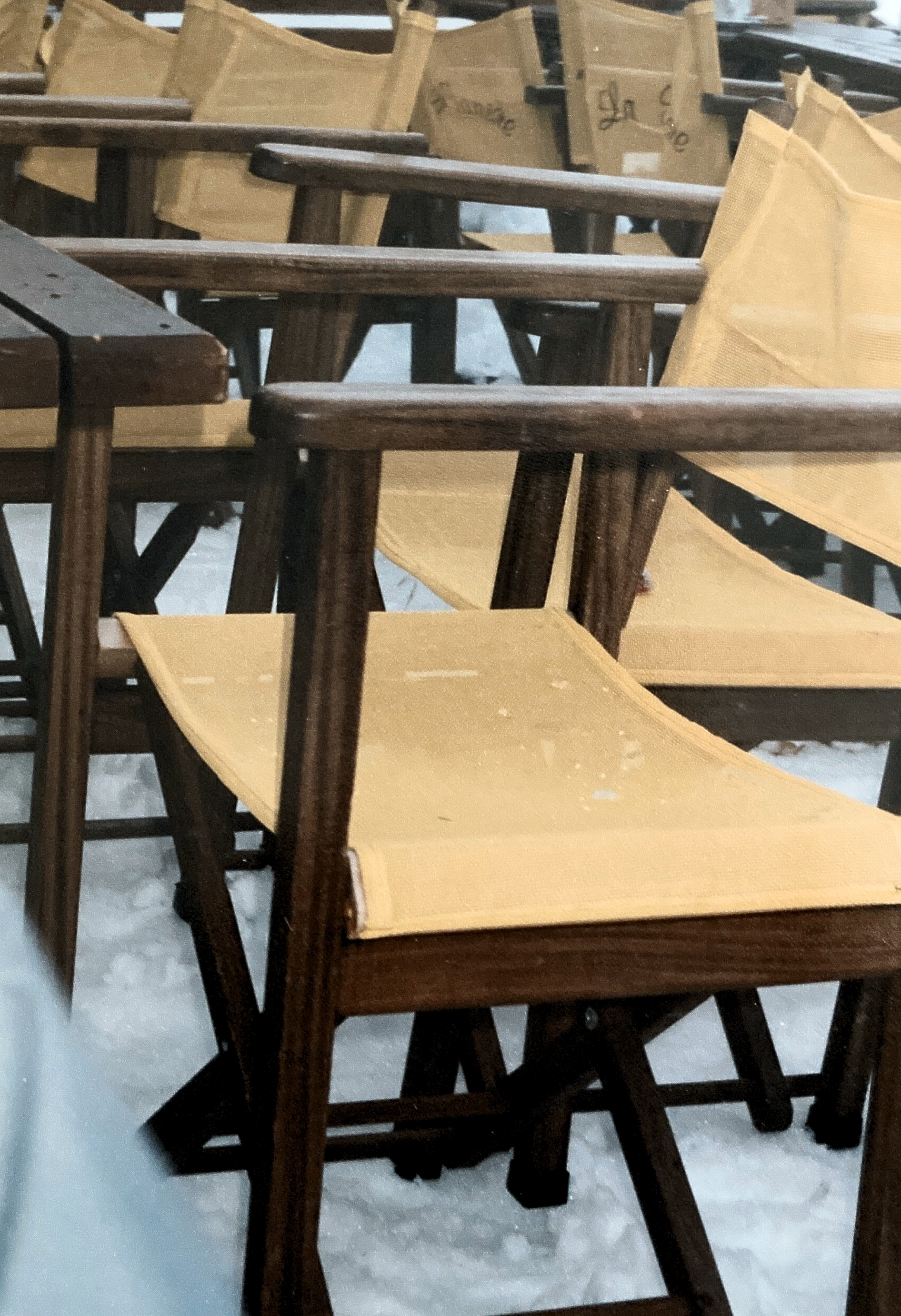 Eine Reihe Regiestühle stehen aufgereiht im Schnee