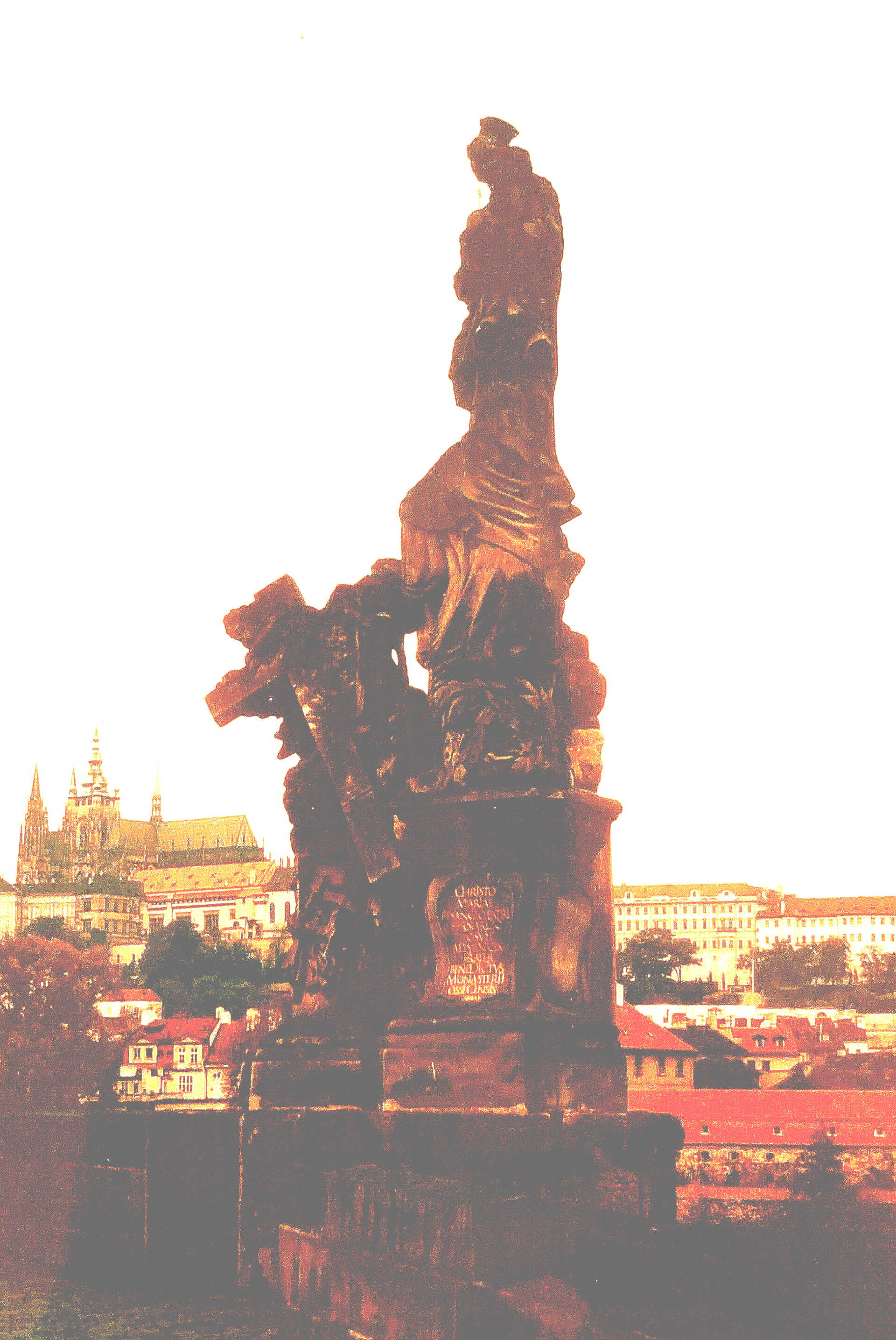 Eine Statue eines Mannes, der auf einem Felsen steht, mit einer Stadt im Hintergrund