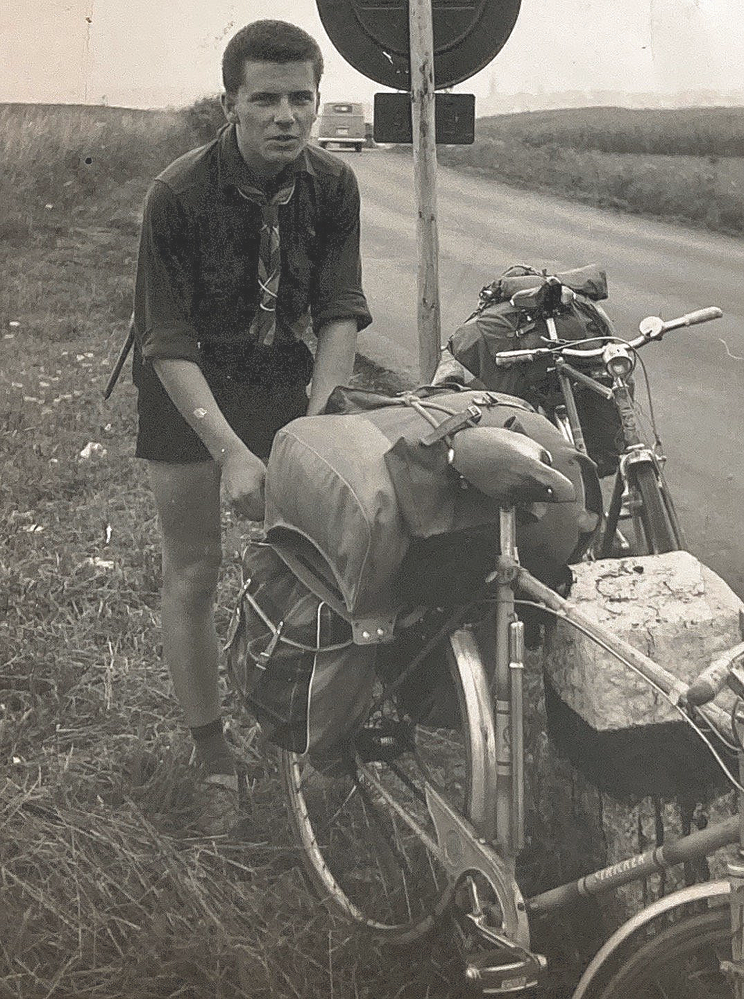 Ein Mann steht neben einem Fahrrad am Straßenrand