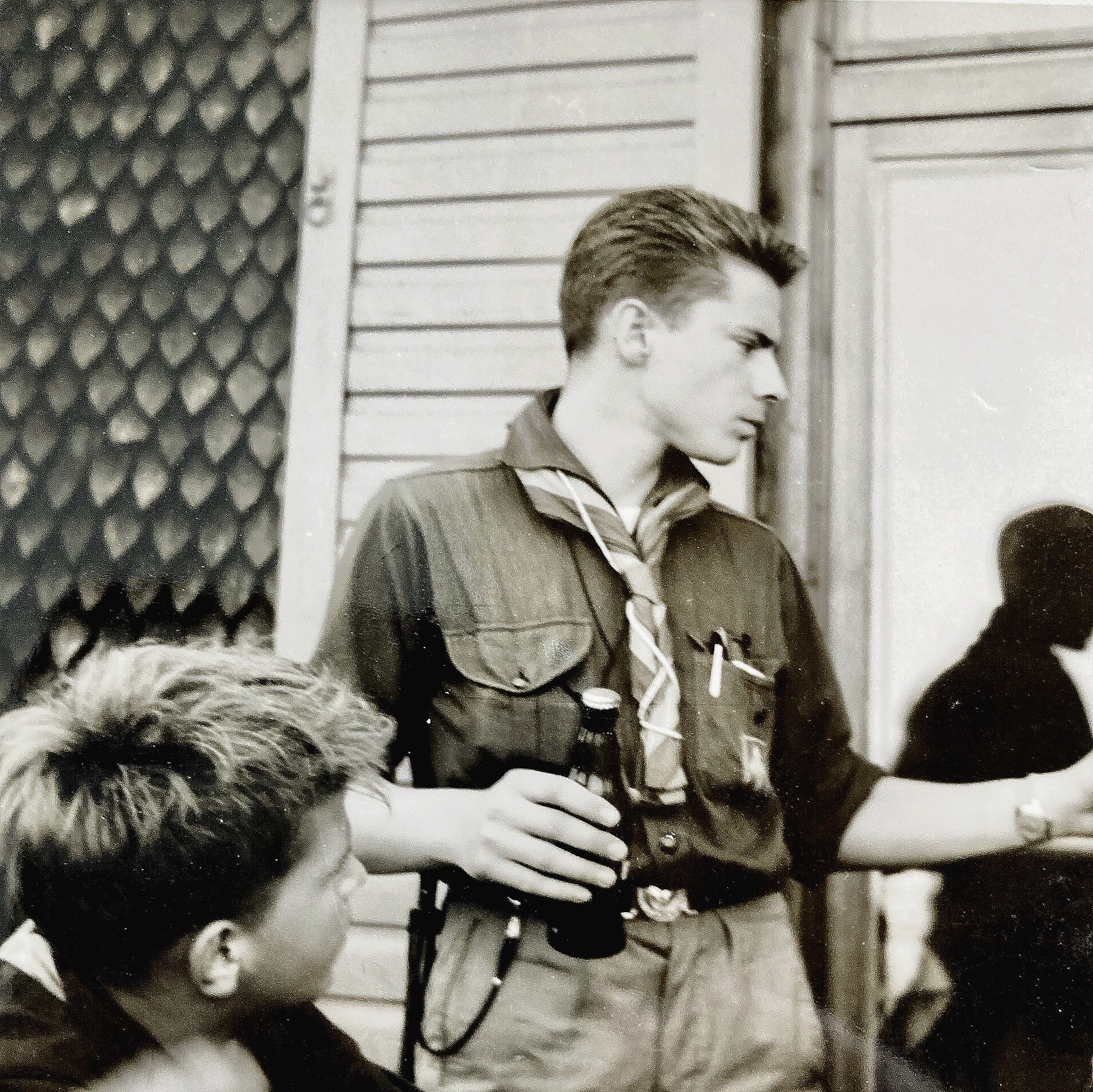 Ein Schwarzweißfoto eines Mannes, der eine Flasche hält