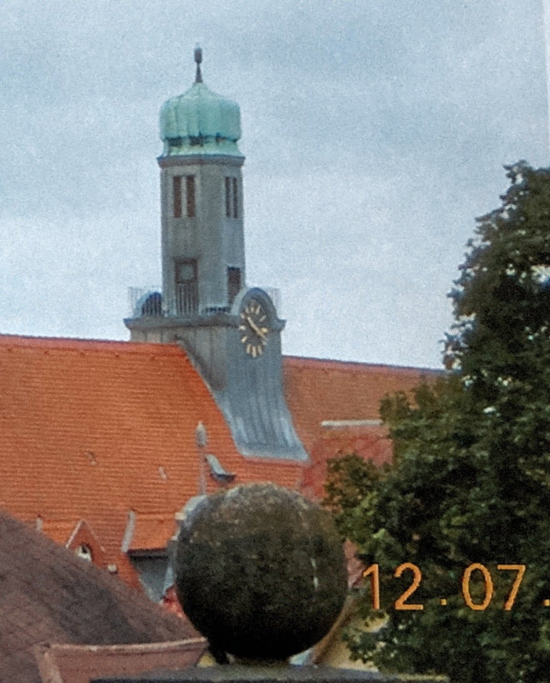 Ein Glockenturm auf einem Gebäude mit der Zeit 12:07