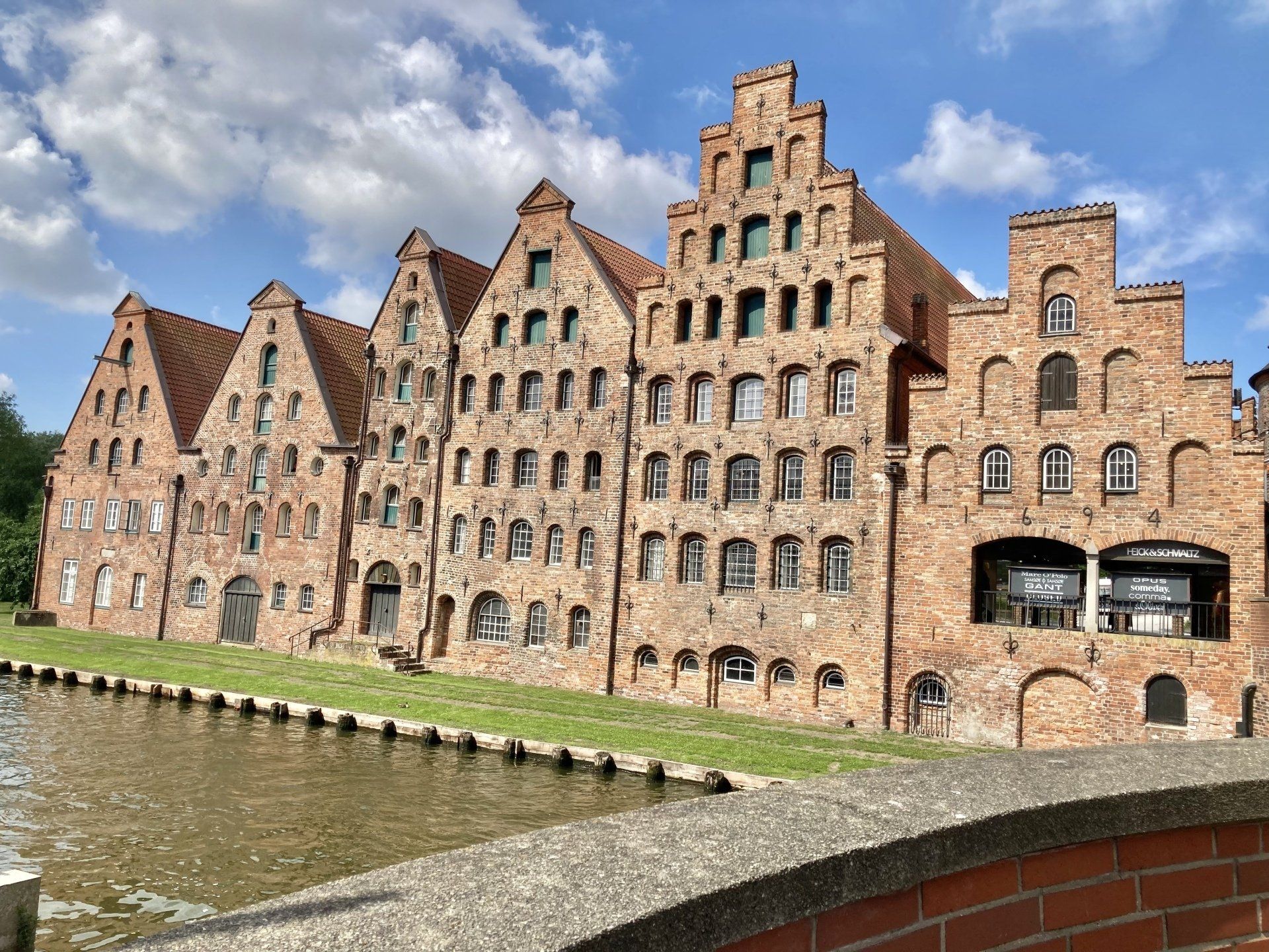 Neben einem Fluss steht ein großes Backsteingebäude.