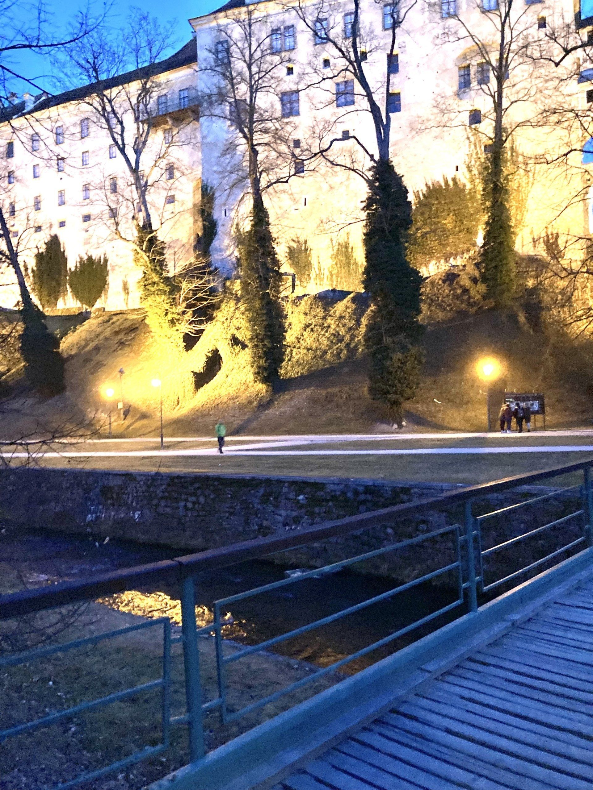 Eine Brücke über einen Fluss mit einer Burg im Hintergrund bei Nacht