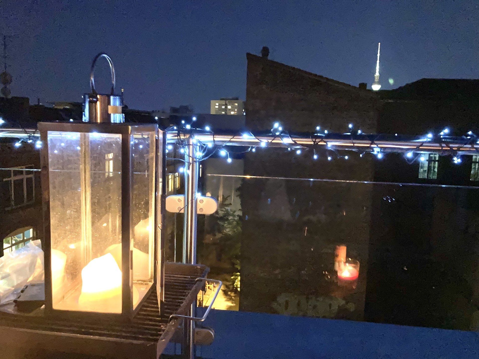 Eine Laterne wird nachts auf einem Balkon angezündet