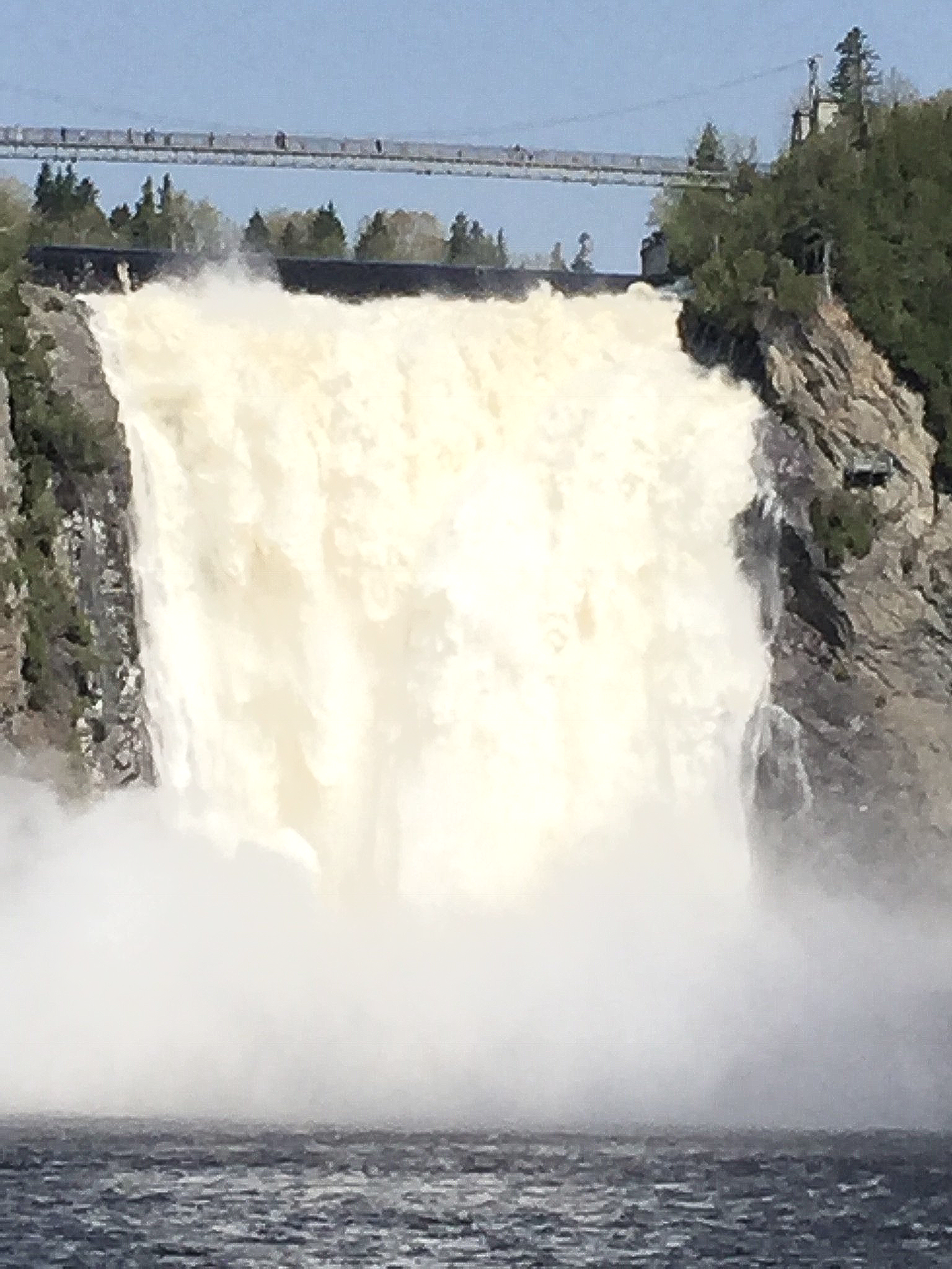 Ein Wasserfall stürzt von einer Klippe in ein Gewässer.