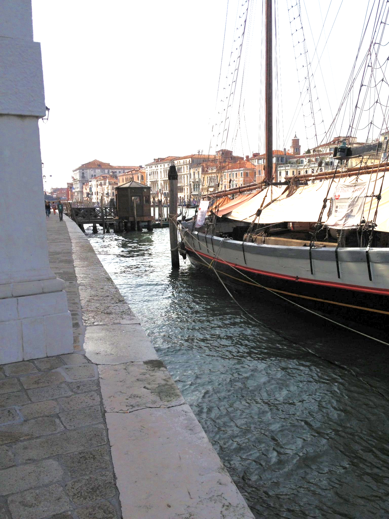 Ein Boot liegt in einem Hafen mit Gebäuden im Hintergrund