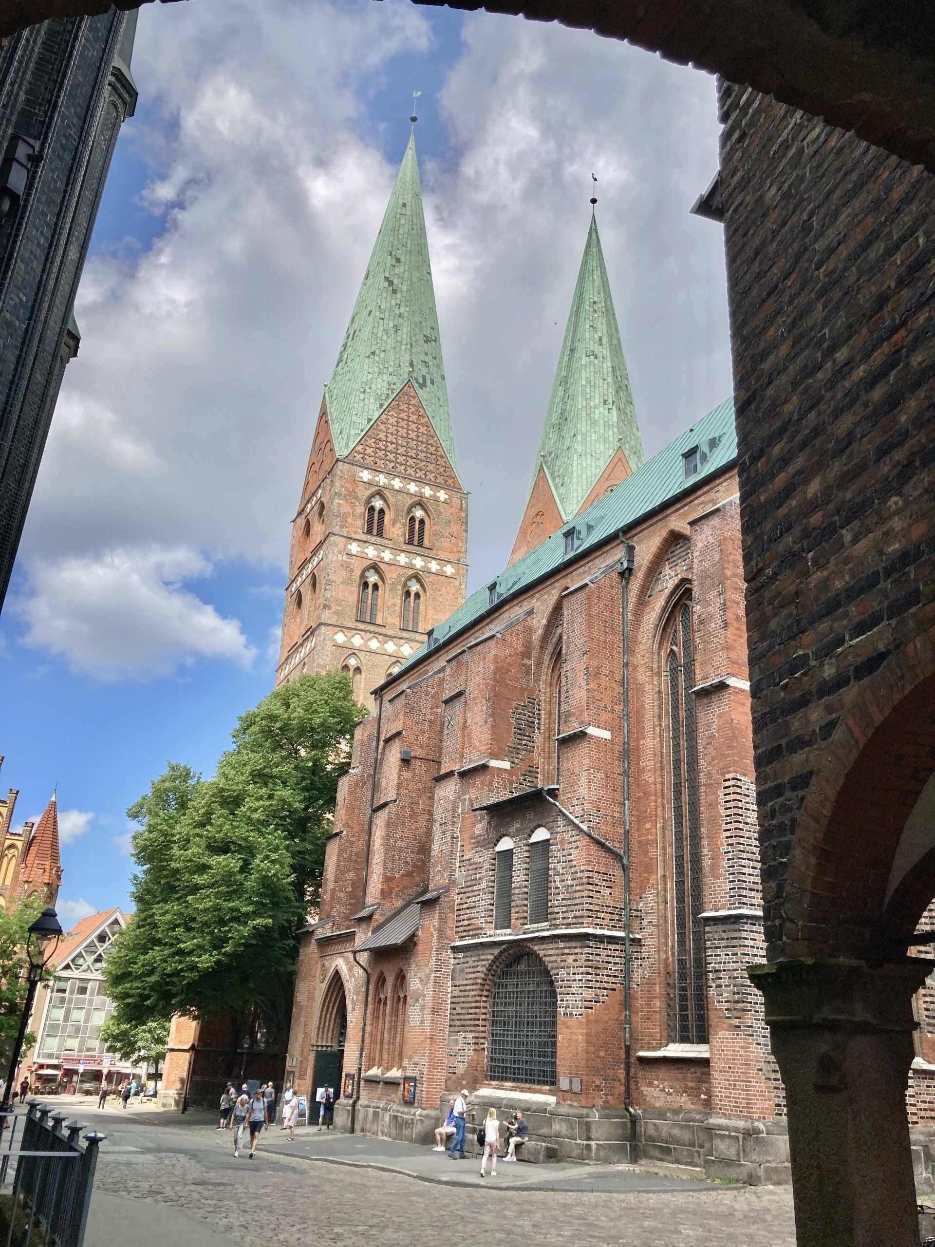 Ein großes Backsteingebäude mit grünem Dach und zwei Türmen
