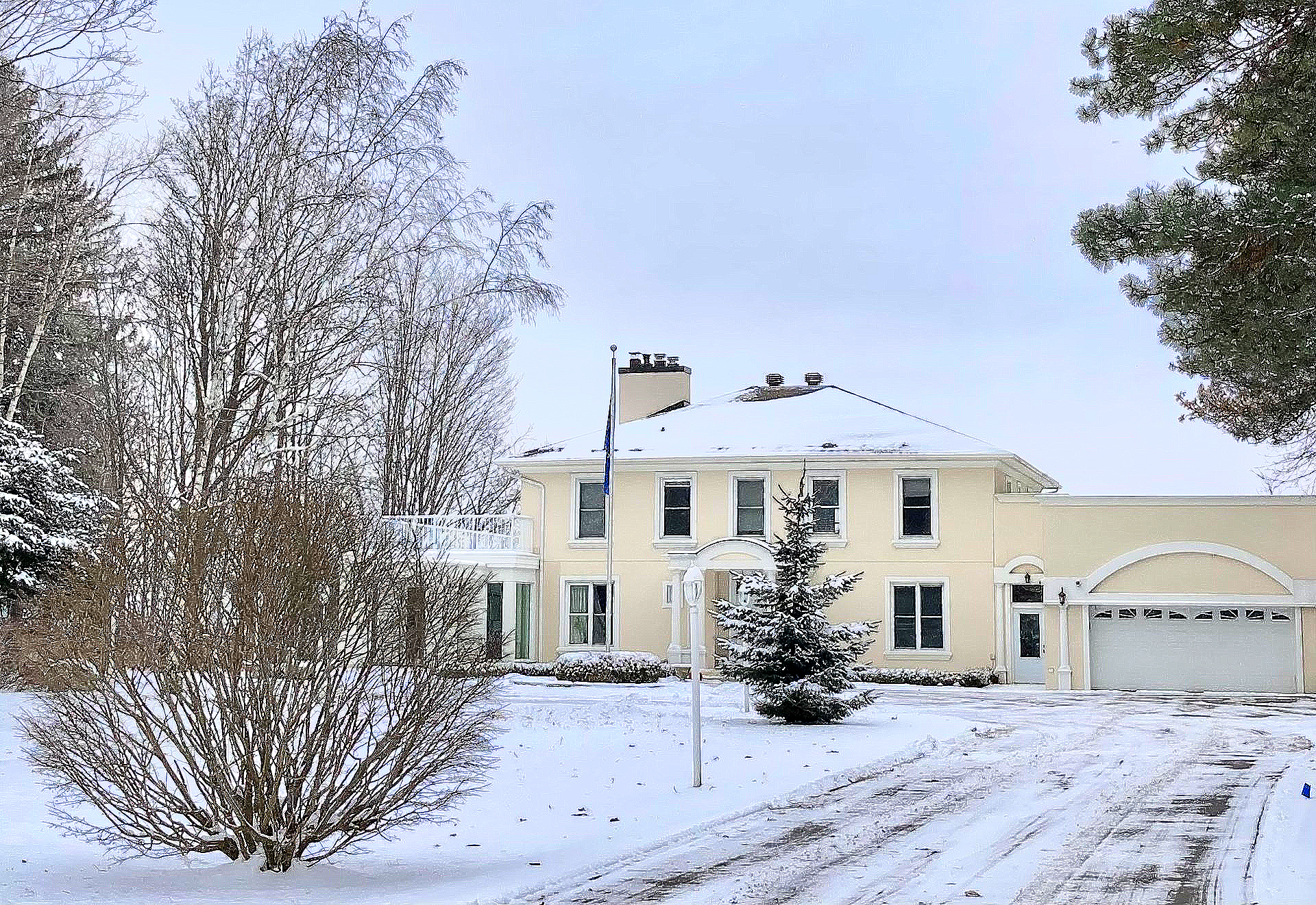 Ein großes Haus ist mit Schnee bedeckt und Bäume sind mit Schnee bedeckt.