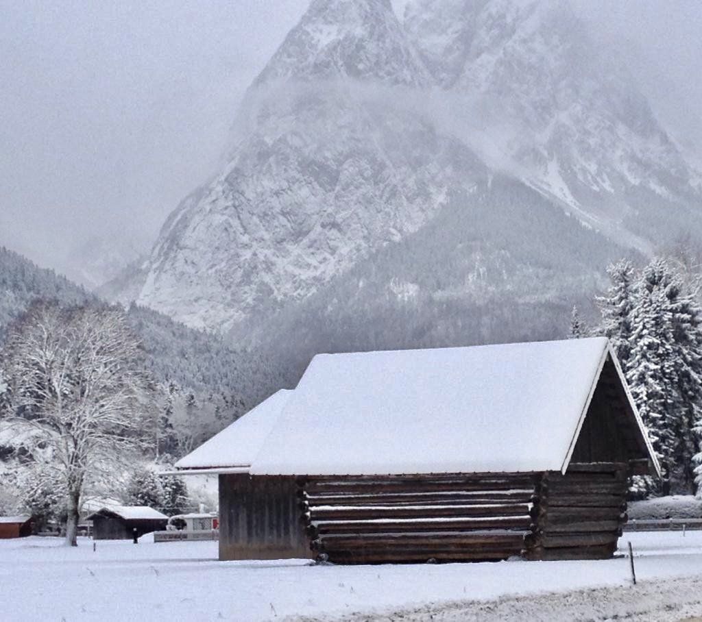 Eine Blockhütte im Schnee mit Bergen im Hintergrund