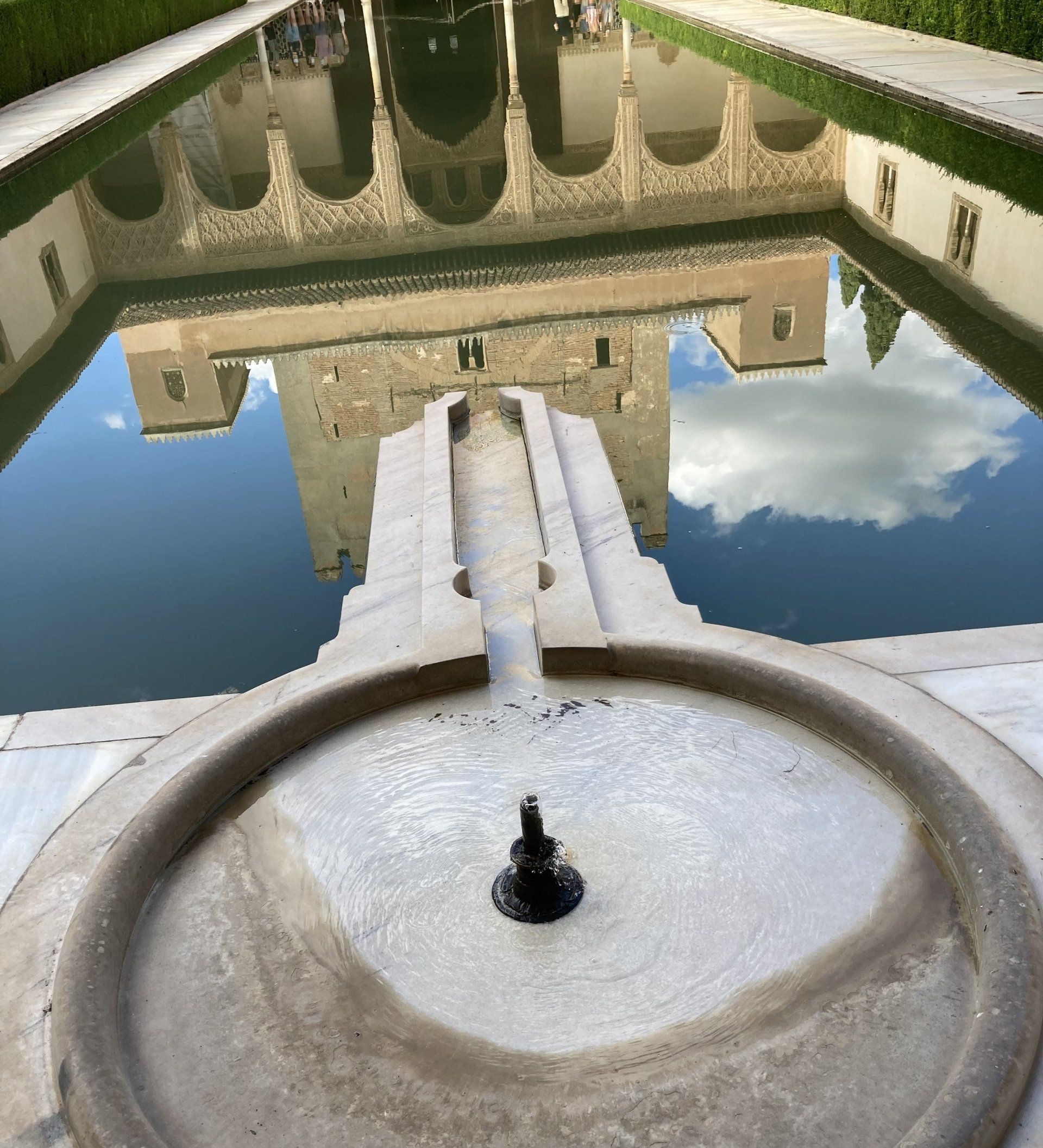 Ein Brunnen mit der Spiegelung eines Gebäudes im Wasser