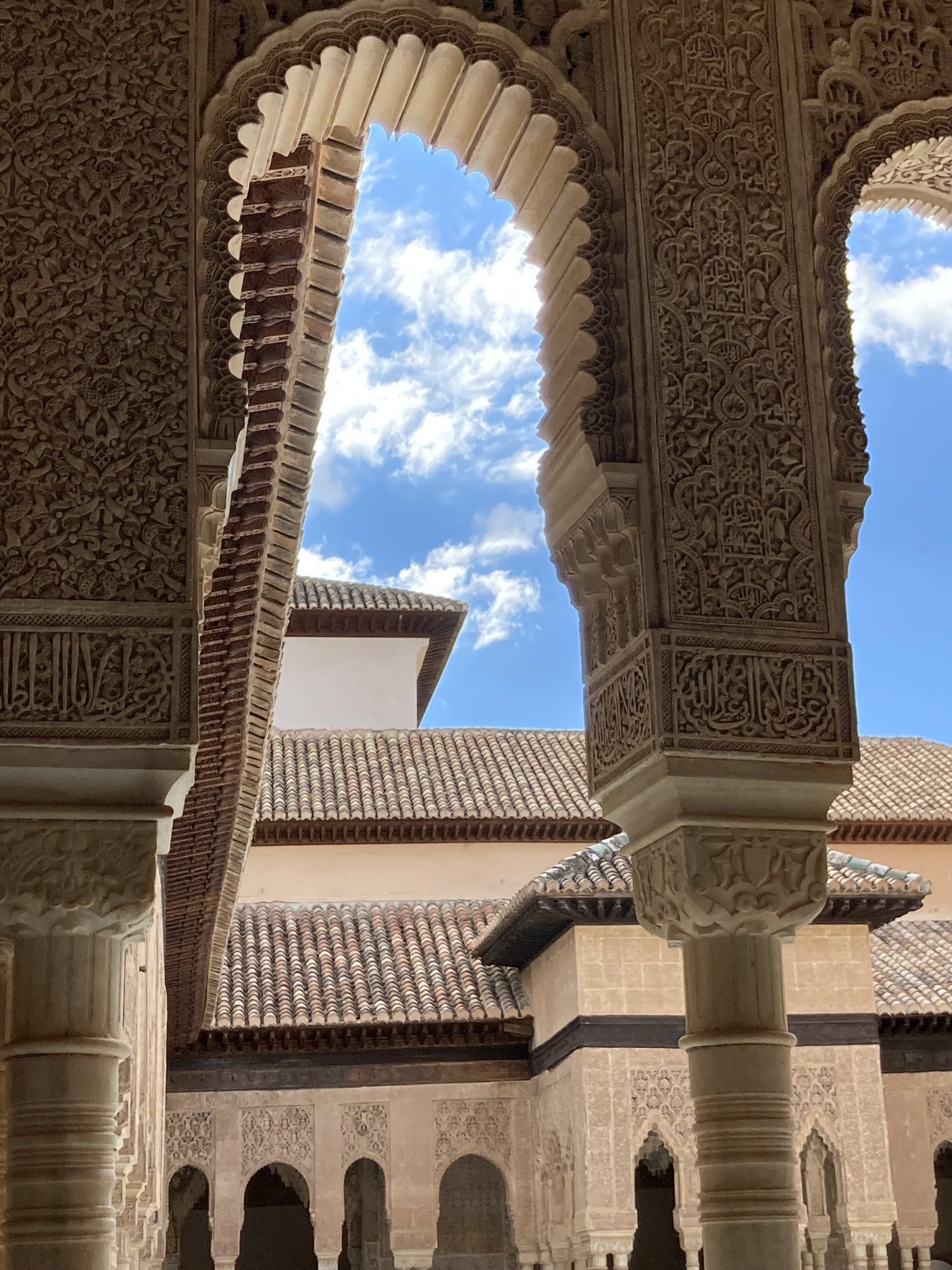 Ein Gebäude mit Bögen und Säulen und einem blauen Himmel im Hintergrund.