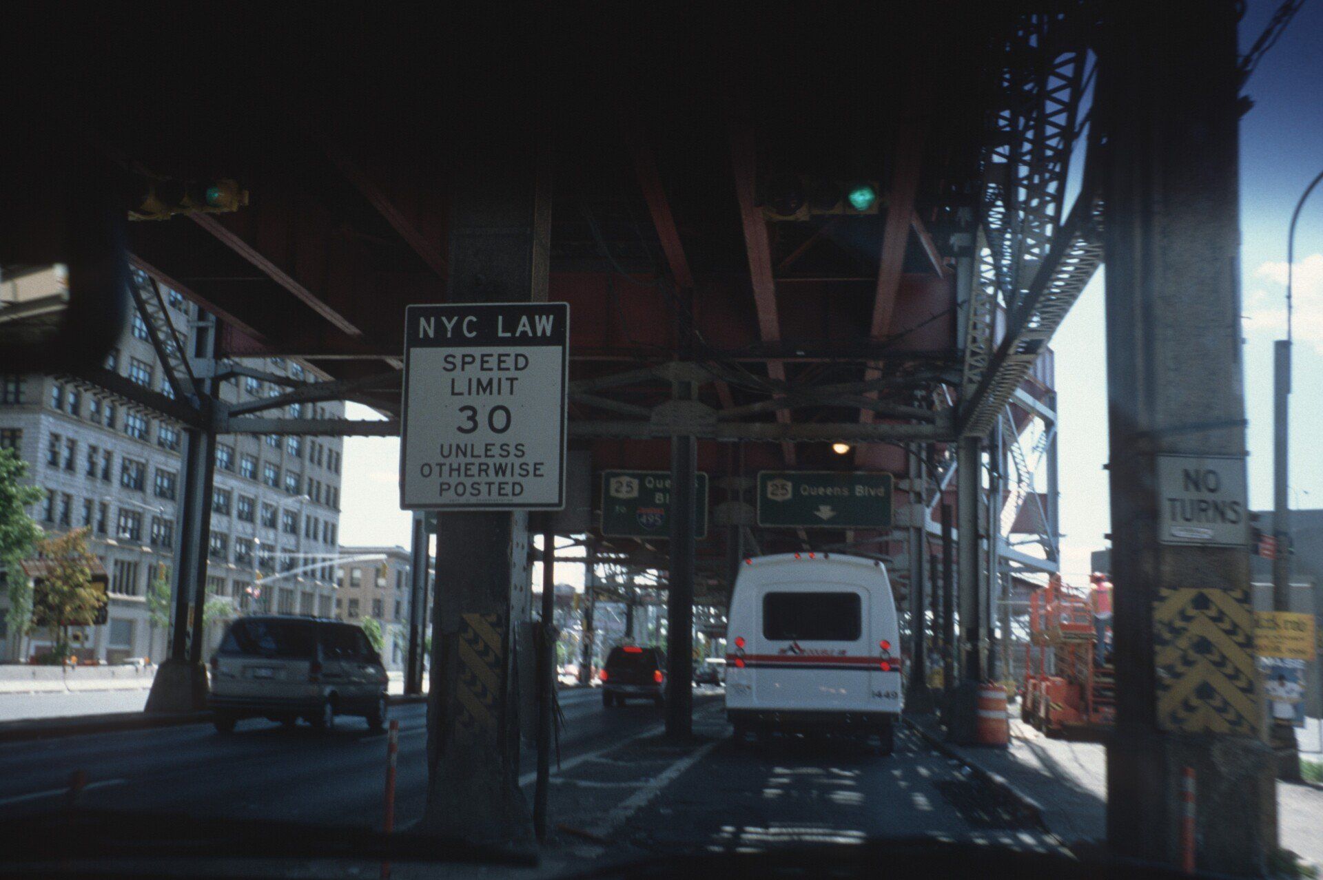 Ein weißer Lieferwagen fährt unter einer Brücke hindurch, wo in New York City eine Geschwindigkeitsbegrenzung von 30 gilt.