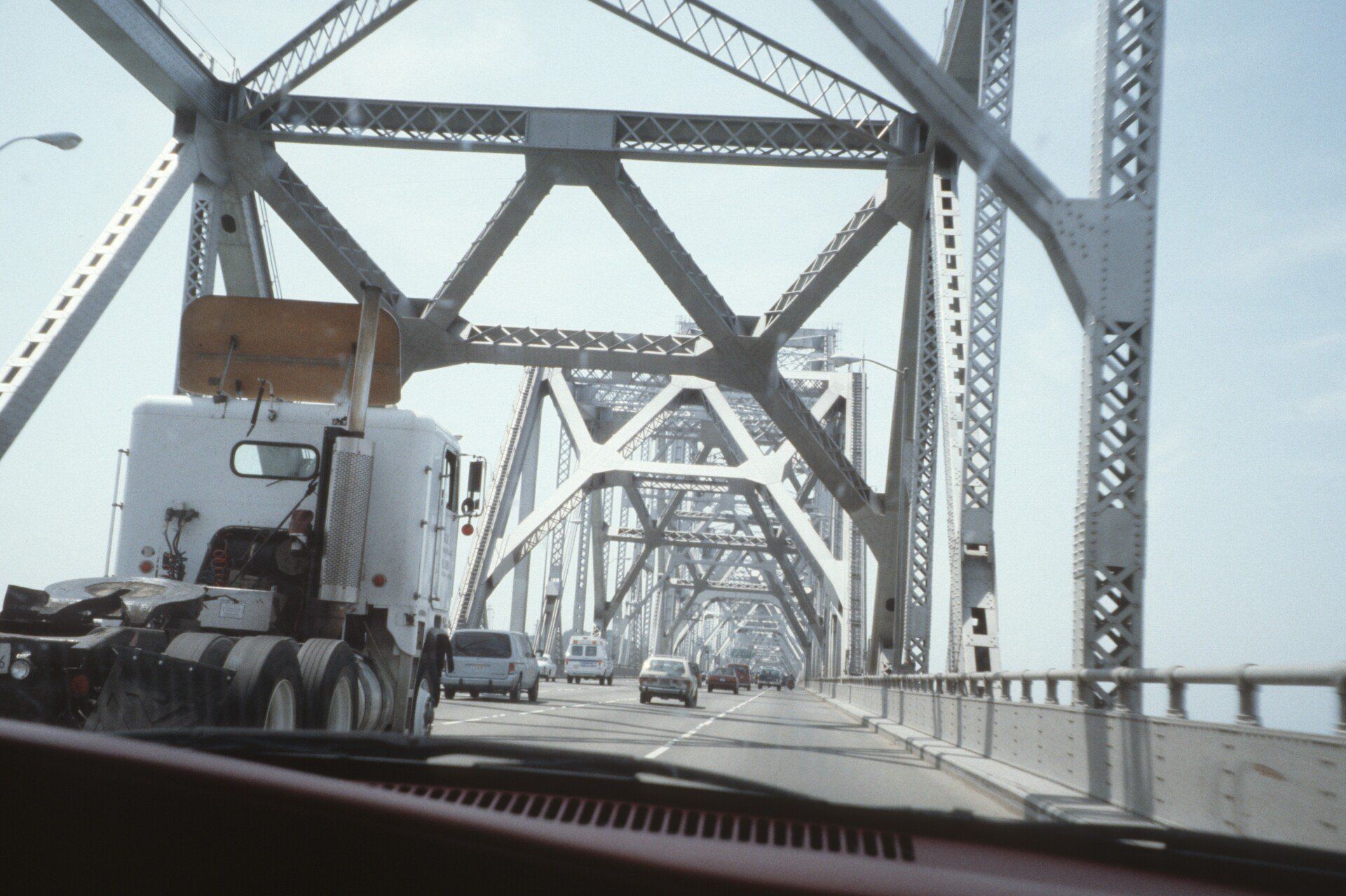 Ein weißer Sattelschlepper fährt über eine Brücke