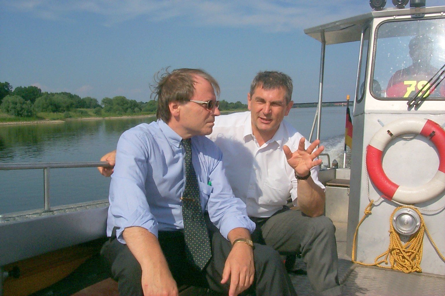 Zwei Männer sitzen auf einem Boot und einer hat die Nummer 7 auf seinem Hemd