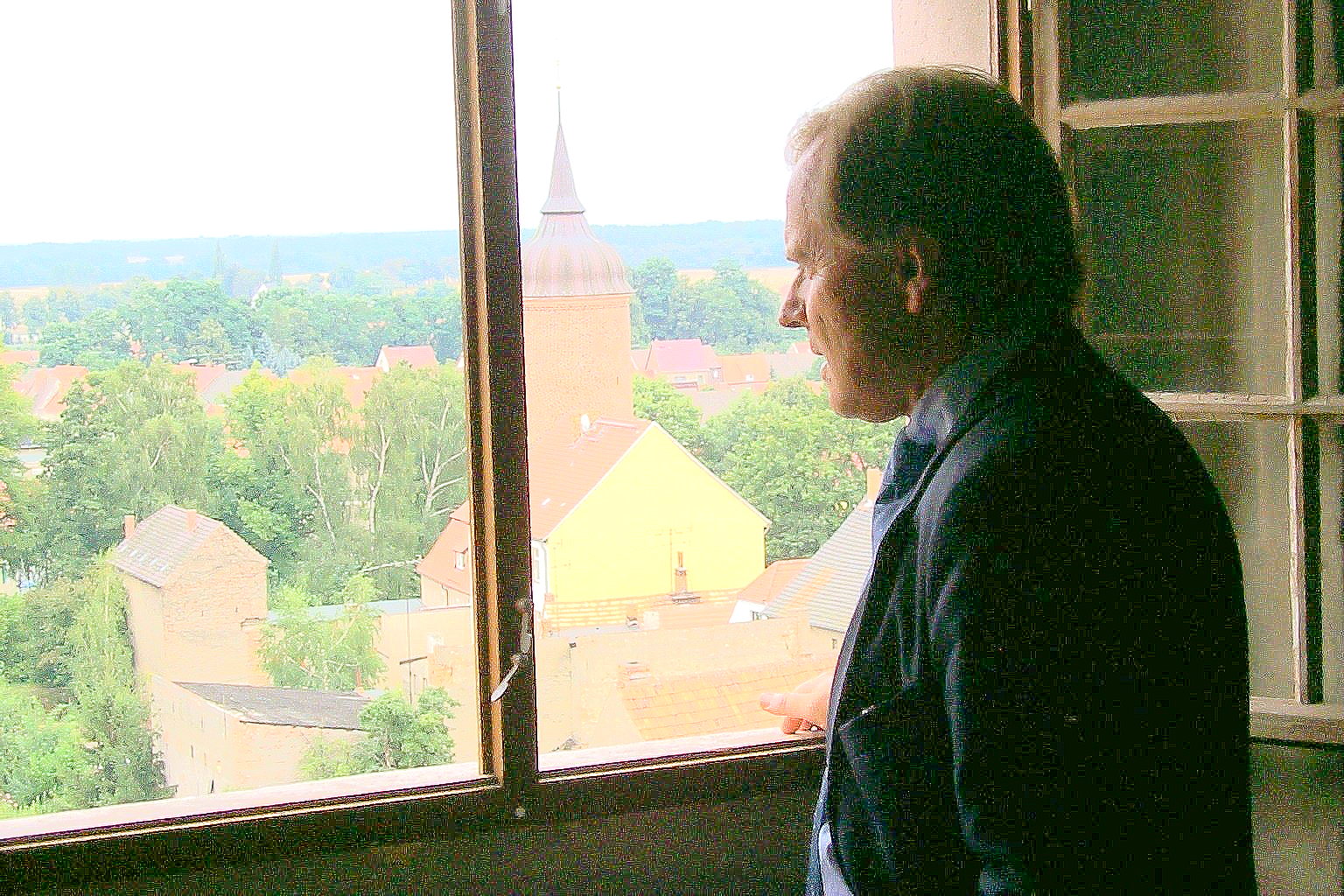 Ein Mann blickt aus einem Fenster auf eine Stadt.