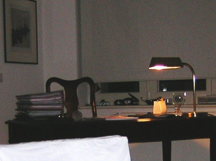 Eine Lampe steht auf einem Schreibtisch in einem dunklen Raum