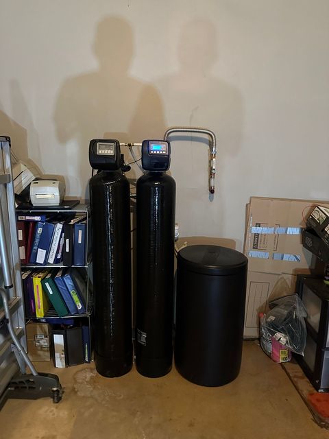 Water filtration system with three black tanks and silver piping.