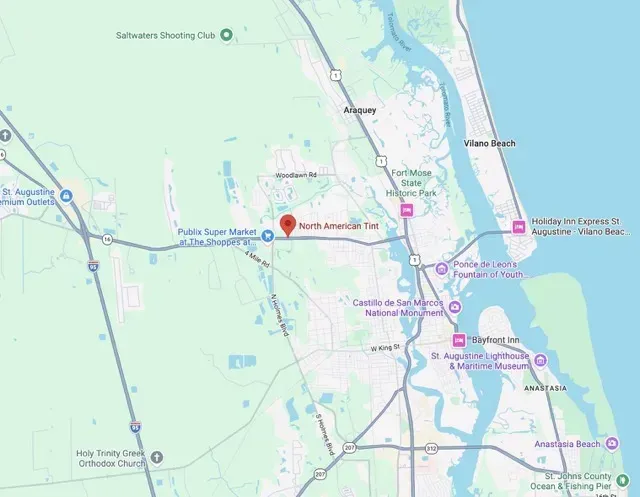 Map showing roads and waterways around a coastal town with a red location pin.