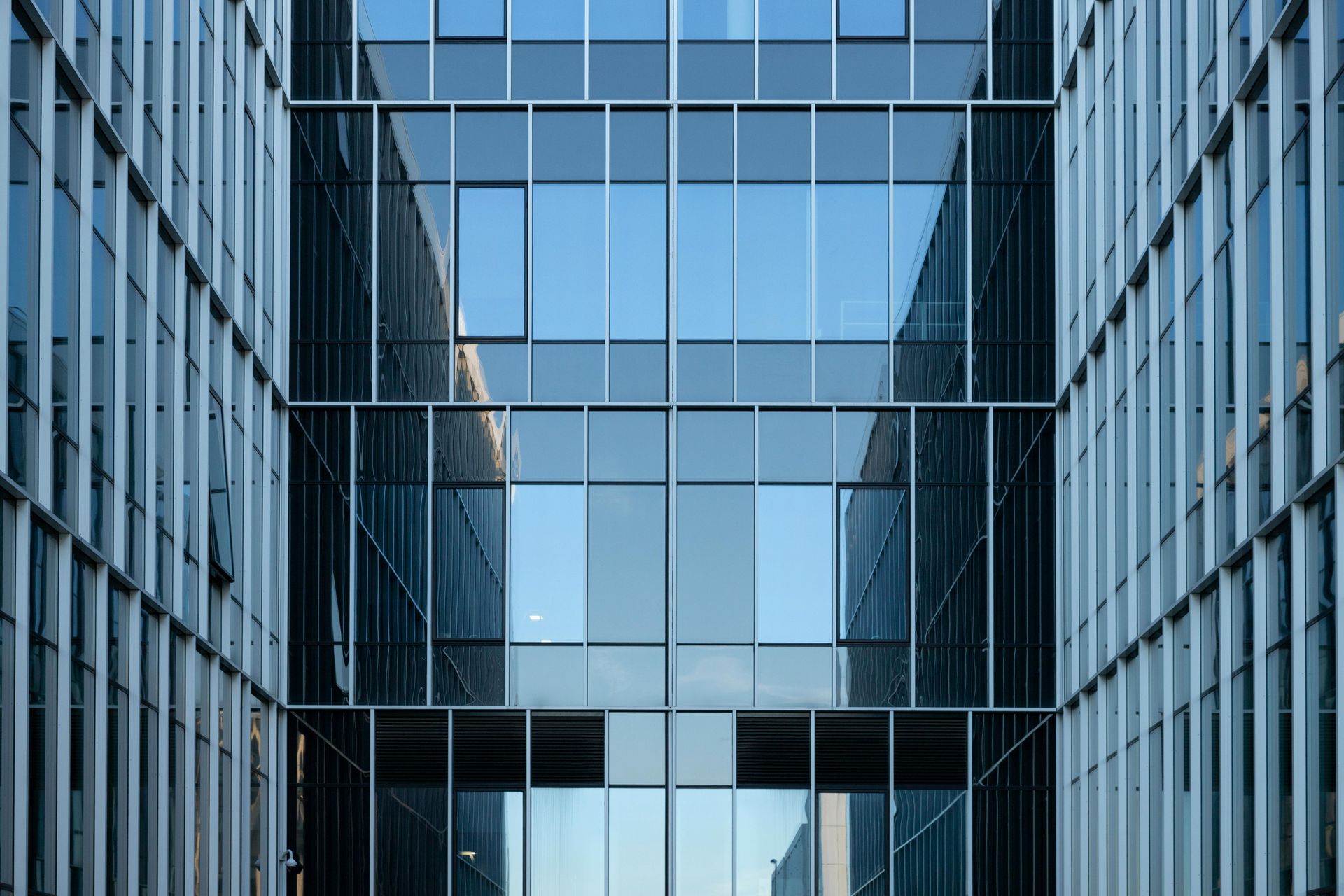 Modern glass office building facade with blue-tinted reflective windows