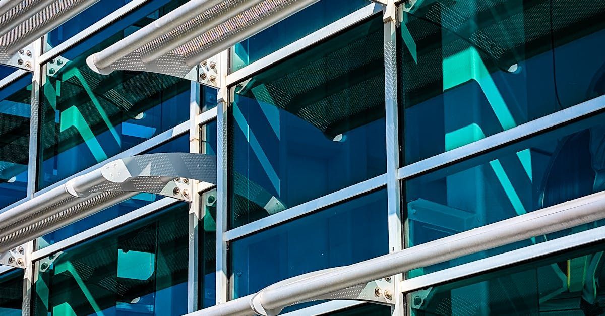 Modern glass building facade with white beams and blue-tinted windows