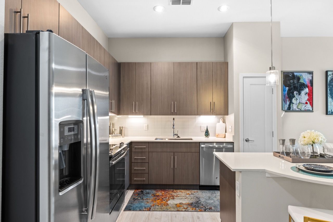 Modern kitchen with stainless steel refrigerator, range, and island.