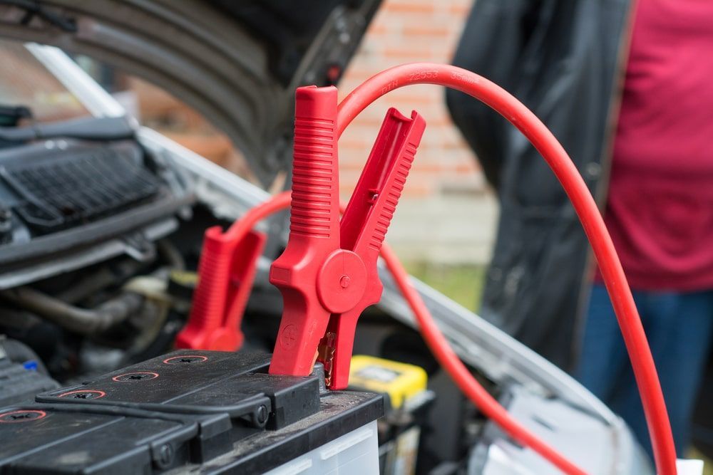 A Car Battery Is Being Charged With Red Jumper Cables — Auto Elect In Parramatta Park, QLD
