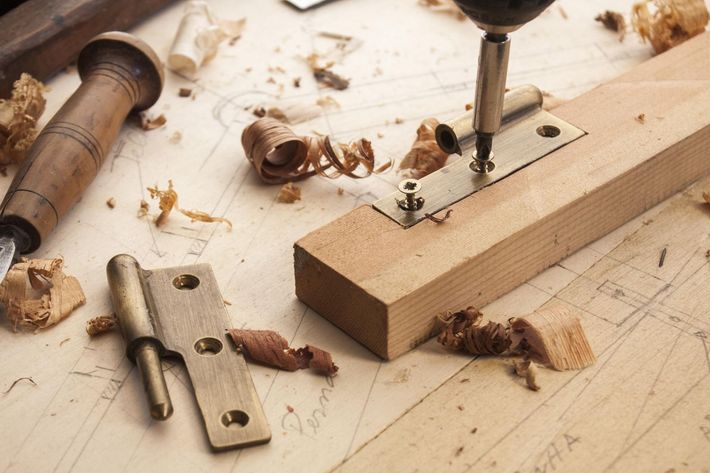 A drill is being used to drill a hole in a piece of wood.