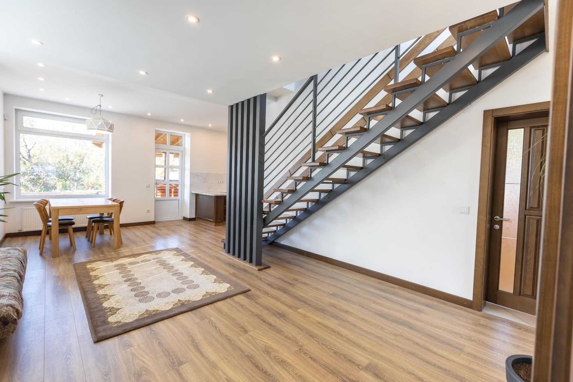 A living room with a staircase leading up to the second floor.