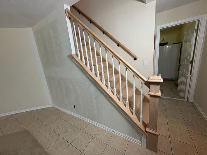 A person is laying a piece of wood on a wooden floor.