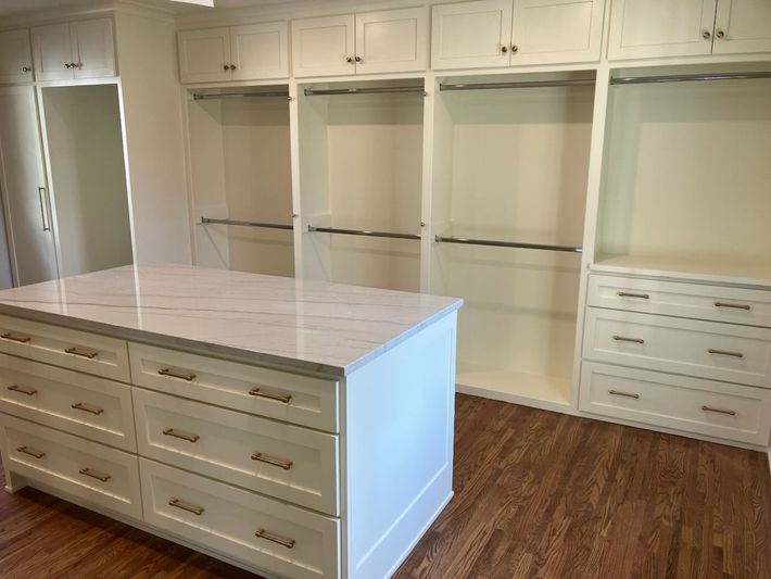 A person is fixing a kitchen cabinet with a screwdriver.