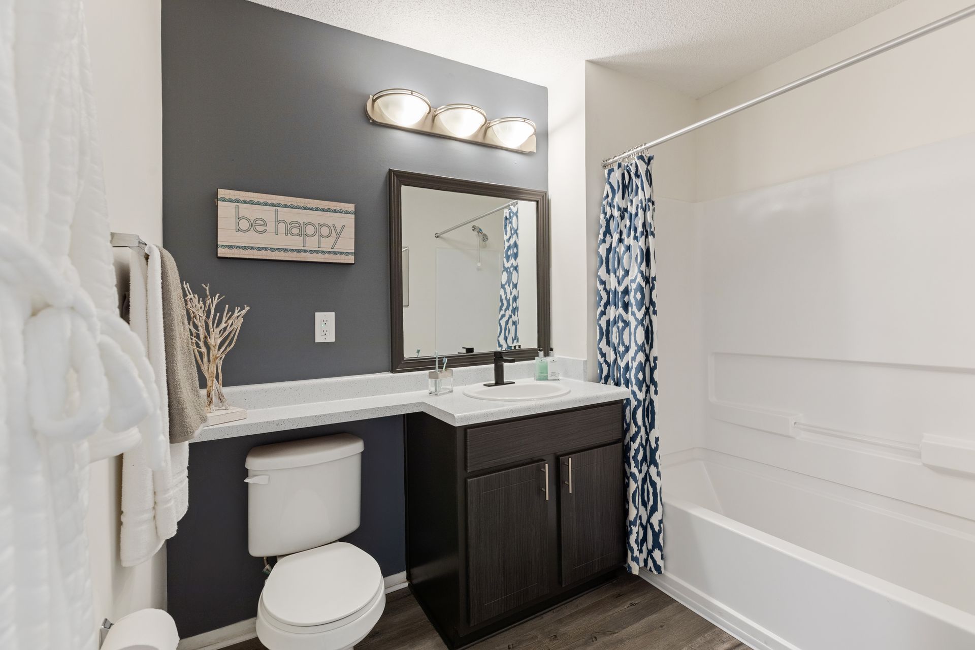 A bathroom with a toilet , sink , mirror and bathtub.