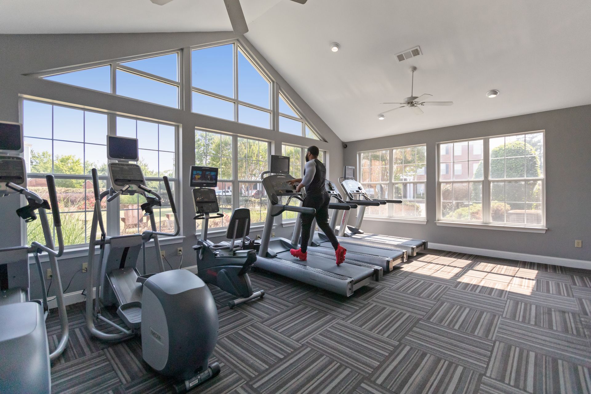 A man is running on a treadmill in a gym.