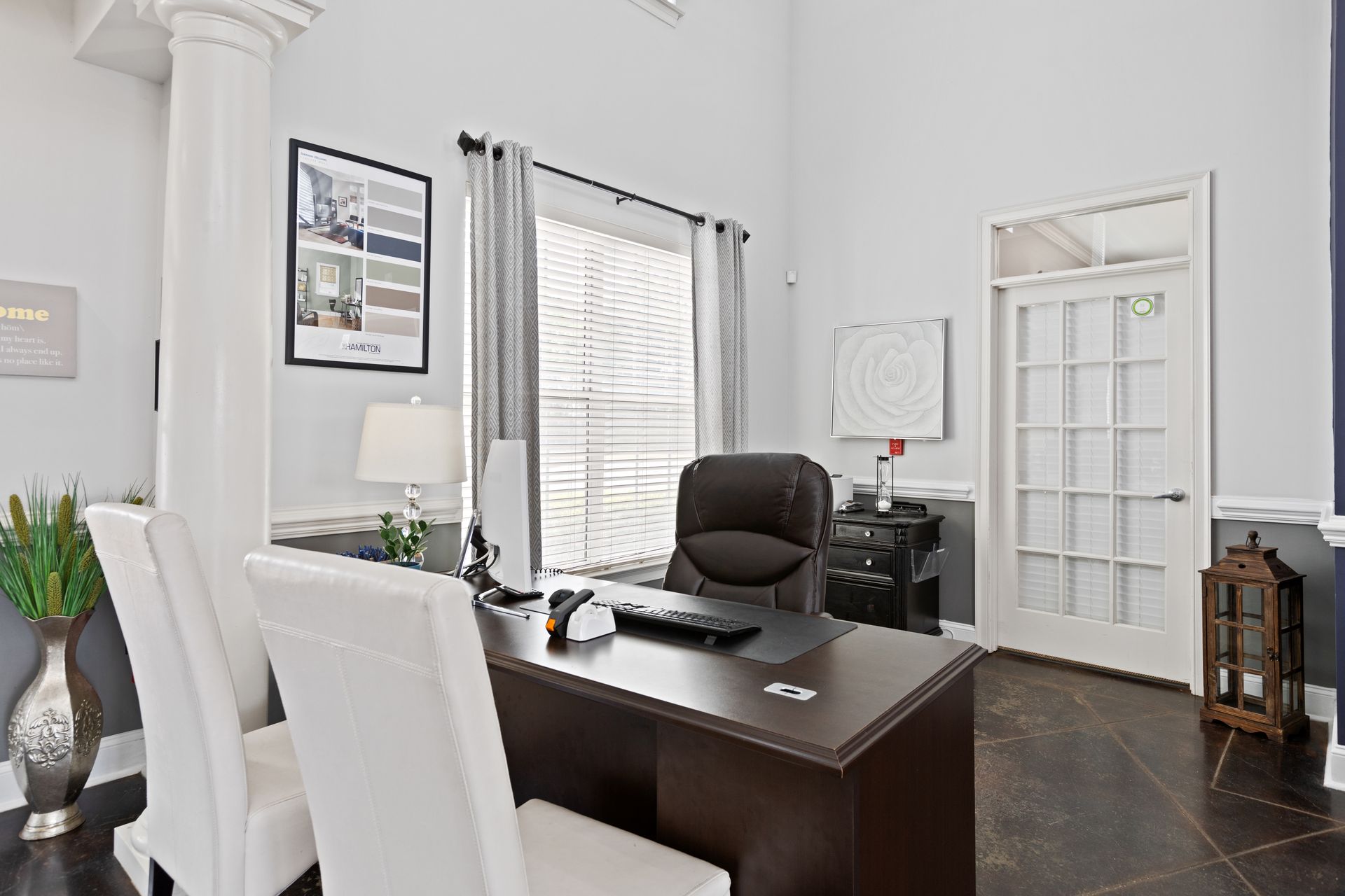 A room with a desk and chairs in it