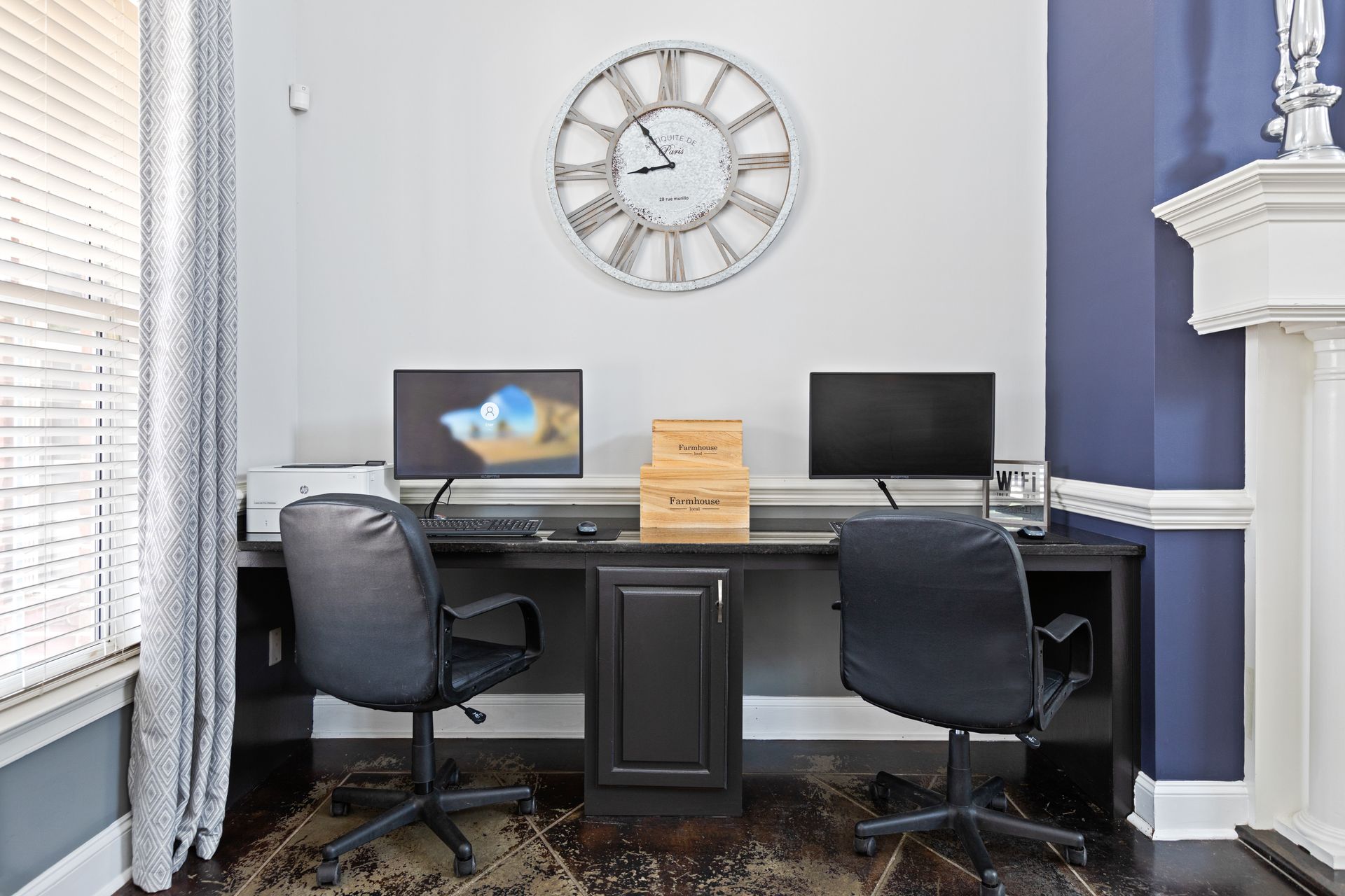 There is a clock on the wall above the desk.
