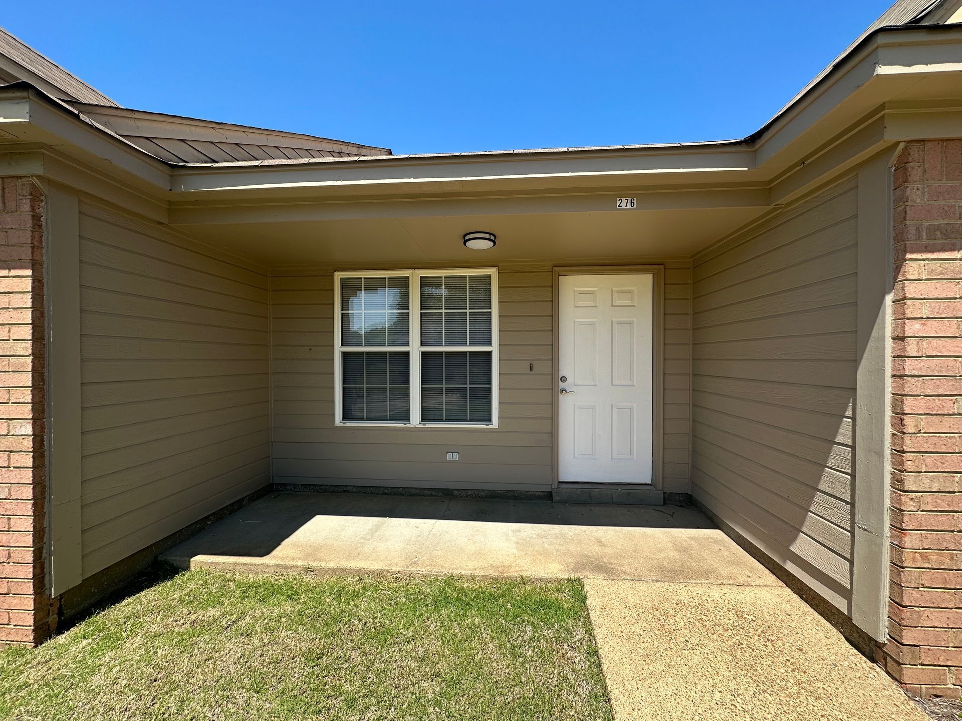 A house with a porch and a white door