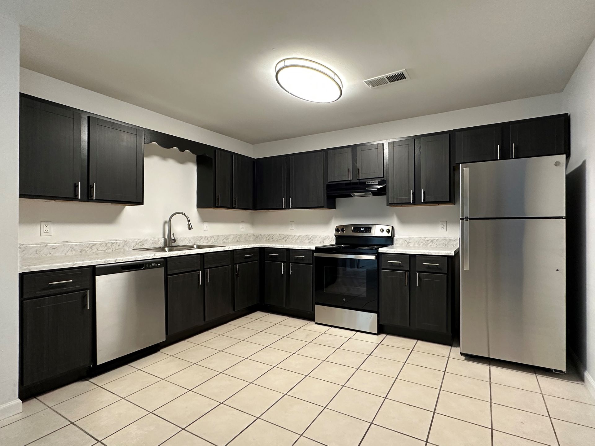 A kitchen with black cabinets and stainless steel appliances