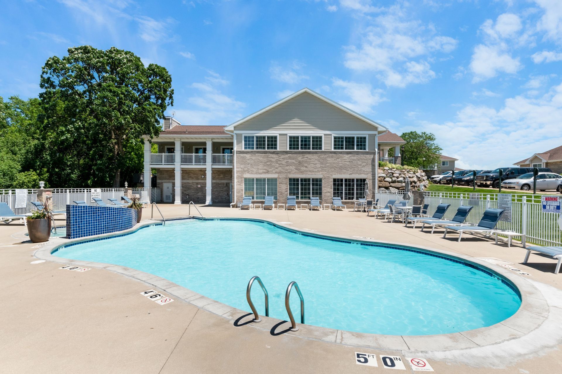 There is a large swimming pool in front of a building.