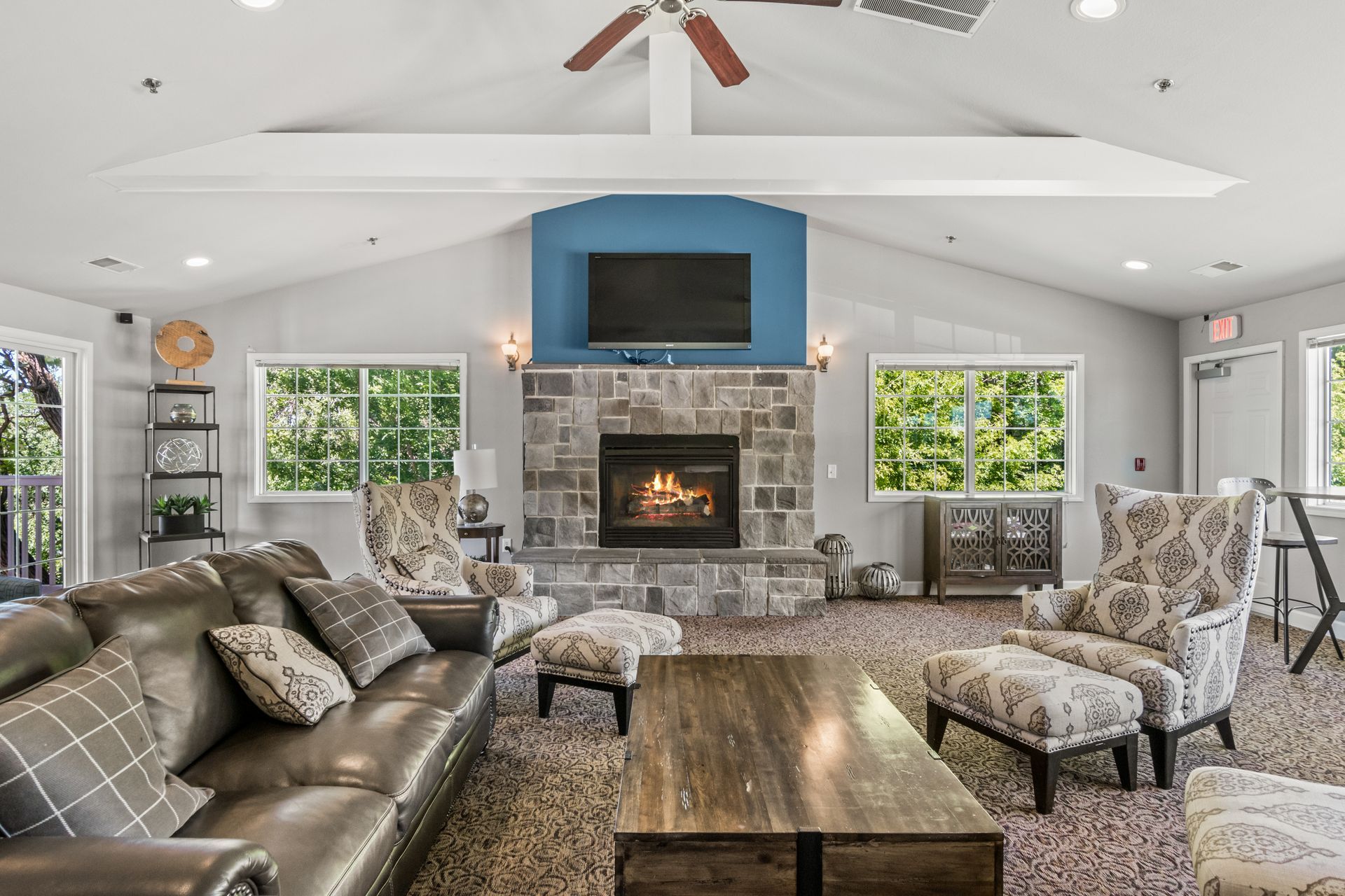 A living room with a couch , chairs , coffee table and fireplace.