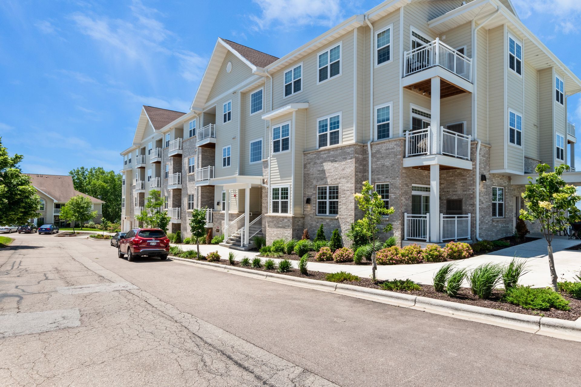 A large apartment building with cars parked in front of it.