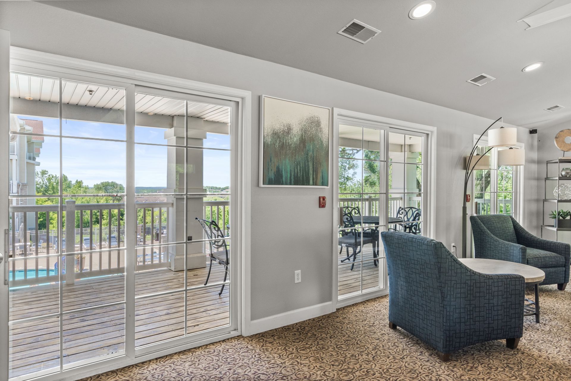 A living room with a lot of windows and chairs.