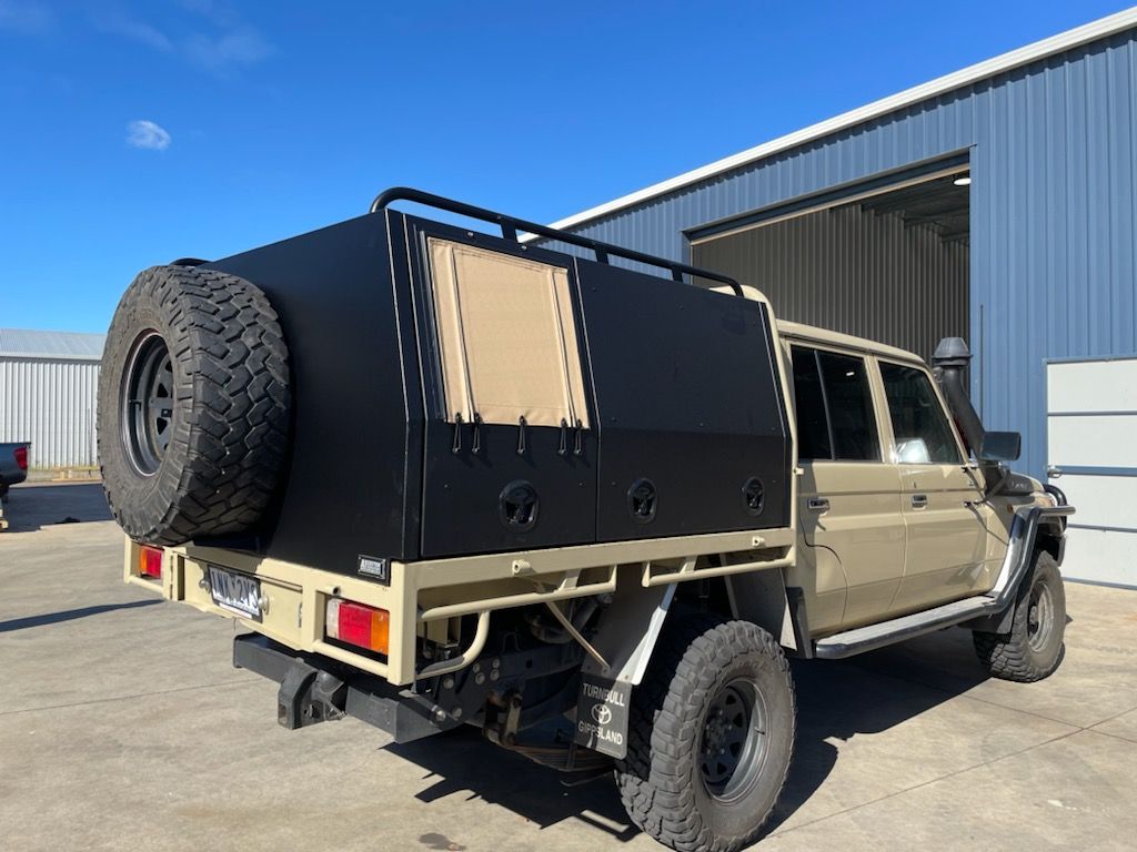 A truck with a canopy is parked in a parking lot.