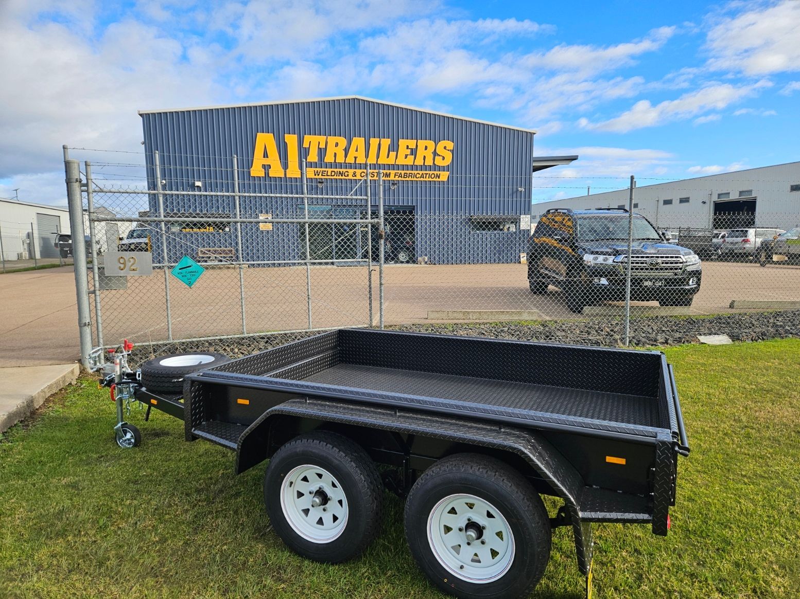 A black trailer with a ladder on top of it