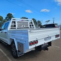 White pickup truck with a flatbed in an outdoor setting. 