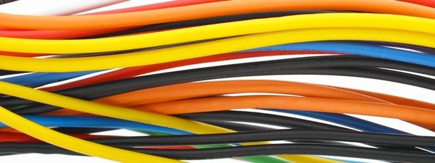 Fili elettrici multicolori avvolti a spirale e disposti secondo uno schema ondulato a strati.