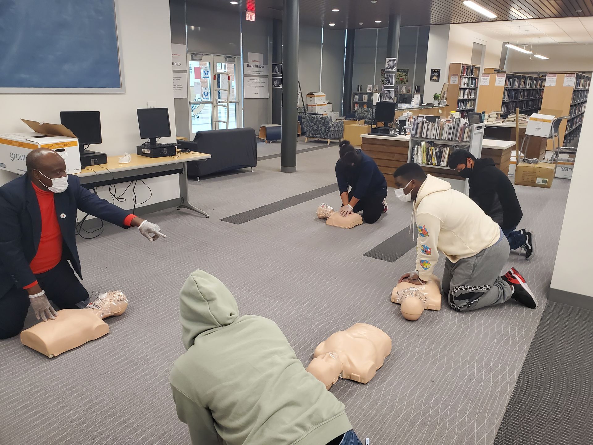 A group of people are practicing first aid on a mannequin