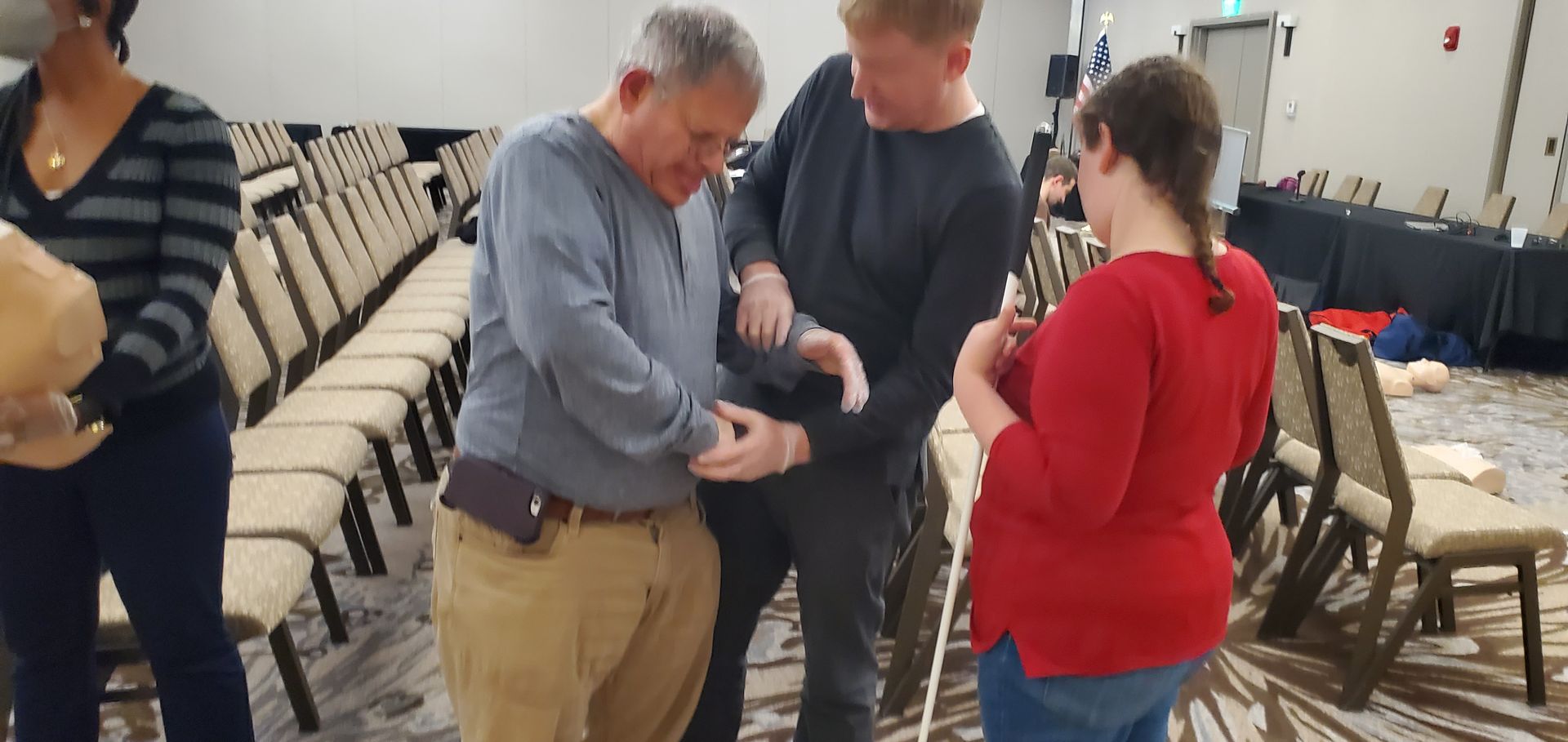 A group of people are standing in a room talking to each other.