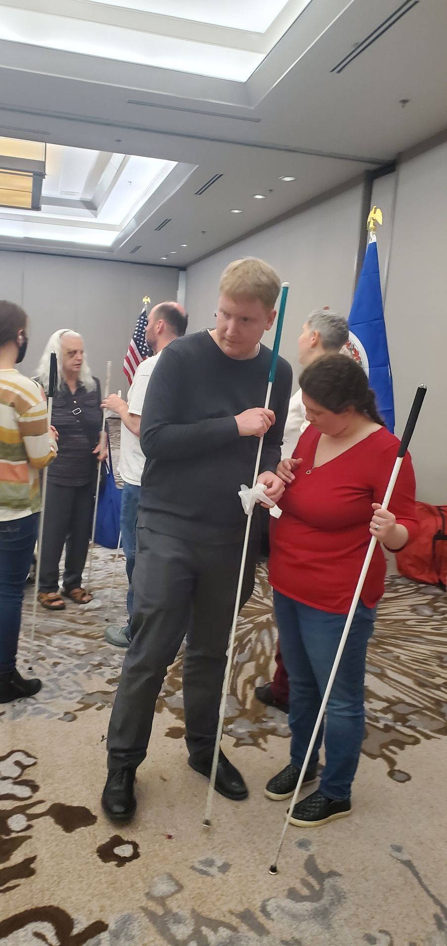 A group of people are standing in a room holding canes.